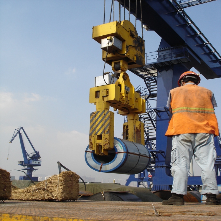 Close-up of vertical steel coil clamp mechanism undergoing maintenance