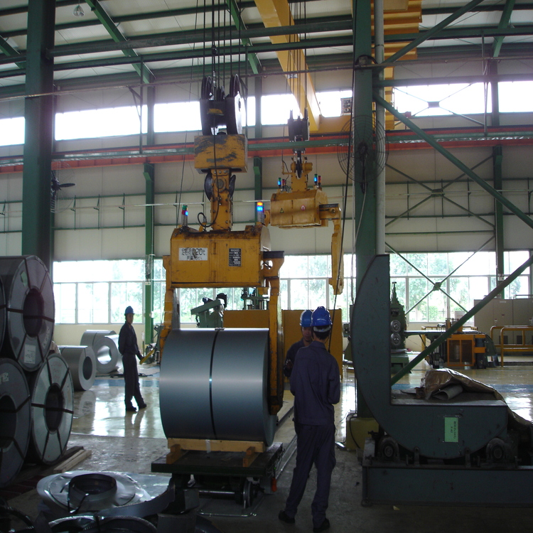 Technician servicing a horizontal steel coil spreader
