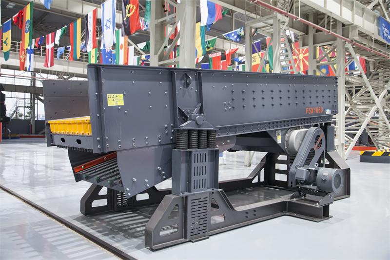 محطة تكسير جرانيت تُظهر جهاز التغذية الاهتزازي عالي الأداء أثناء التشغيل