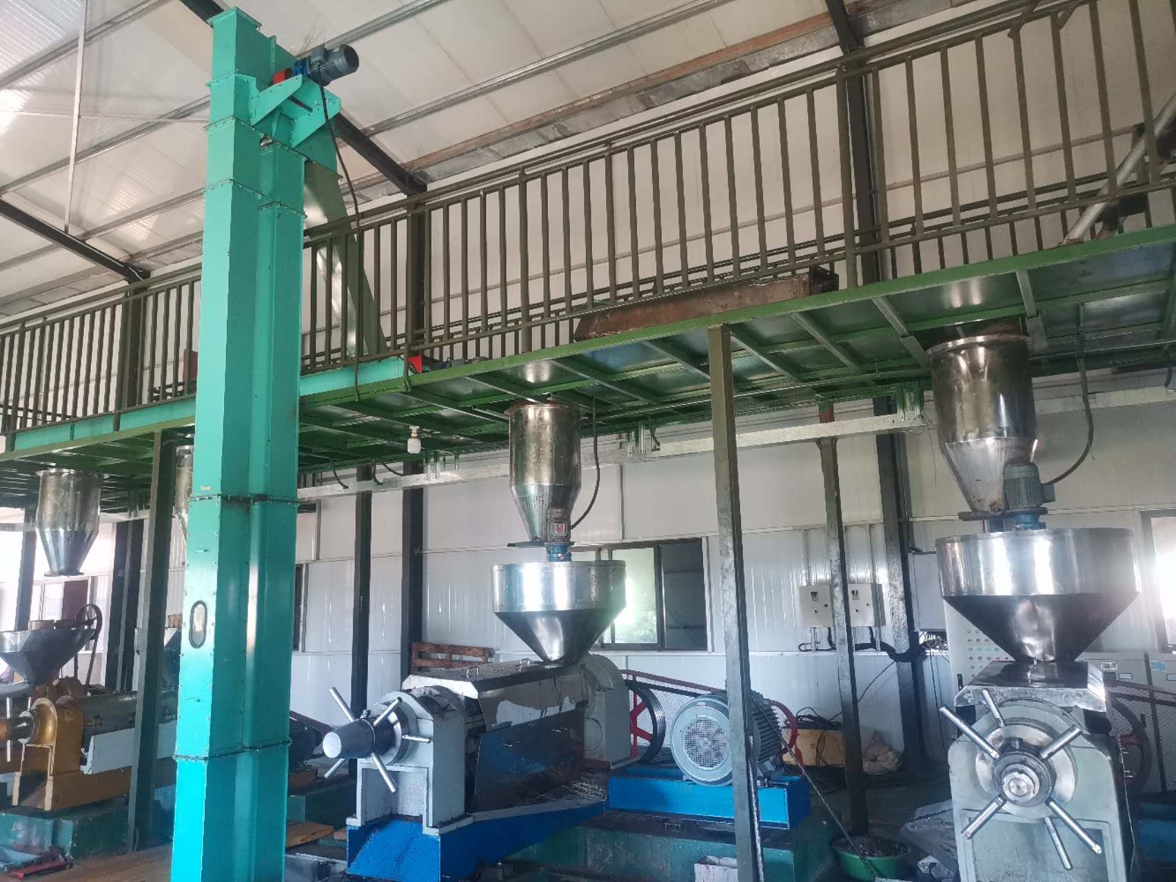 Maquinaria pesada de extracción de aceite por tornillo funcionando dentro de una planta comercial de procesamiento de manteca de karité