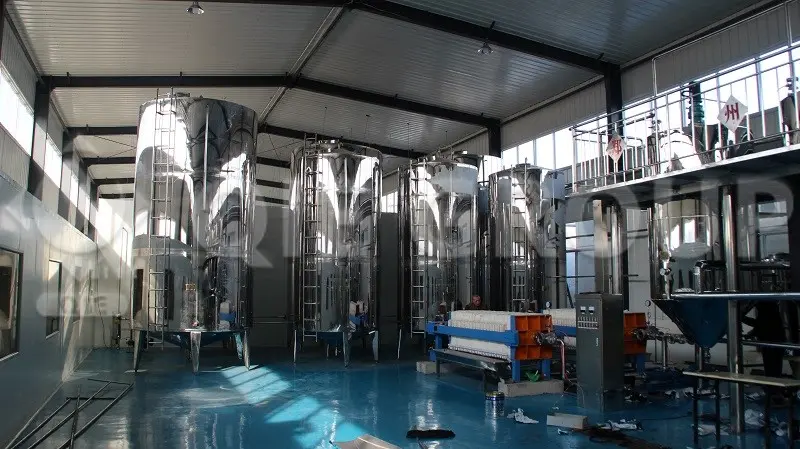 Taller de refinación y descerado continuo de aceite de girasol, con tanques de cristalización de acero inoxidable para la producción de aceite de cocina premium.