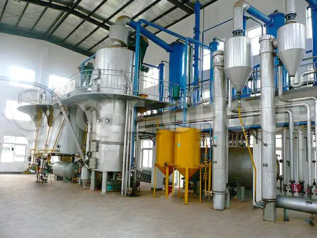 Taller industrial de extracción de aceite de salvado de arroz mediante solventes, equipado con sistemas de control automatizados.