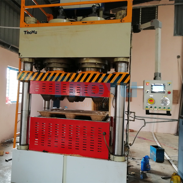 Technical schematic highlighting the four-column hydraulic structure and safety features of the pallet machine