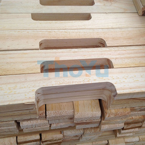 Close-up view of automatic pallet leg nailing machine in operation, showing precise nail placement on wooden legs.