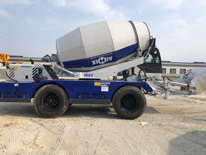 AS-2.6 concrete mixer navigating a narrow mountain path with its articulated chassis fully flexed