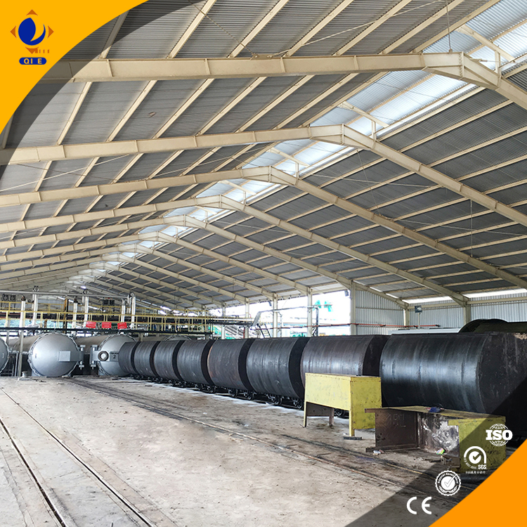 Operator adjusting temperature control panel on a double-screw oil press during hot pressing operation