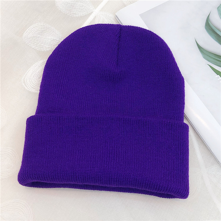 Close-up of a child’s hand holding a custom-printed bucket hat with a small logo visible near the brim, showcasing the quality of the print and soft texture of the cotton.