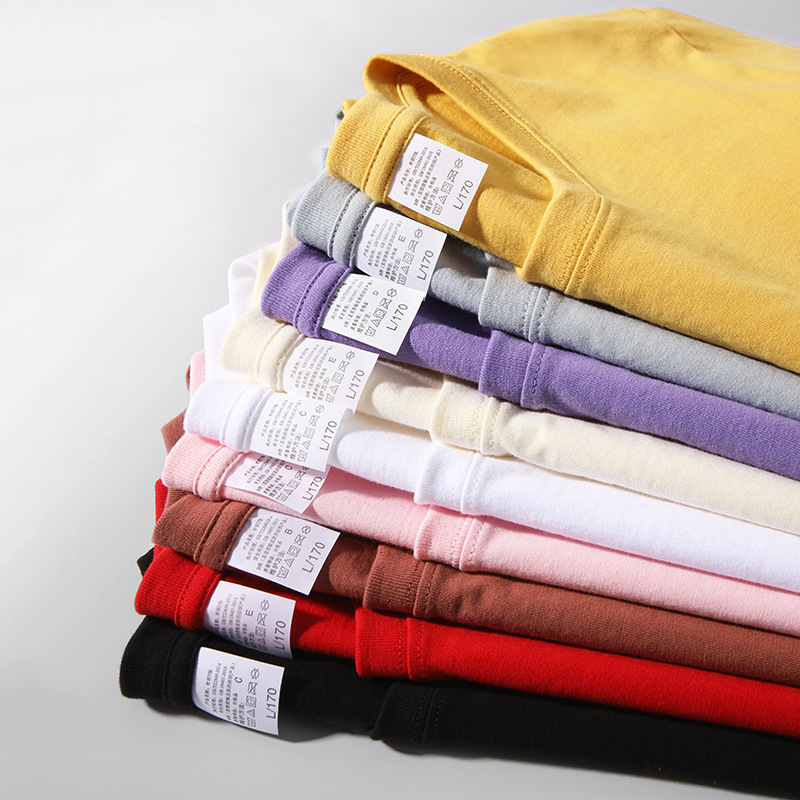 Group of diverse professionals wearing matching branded cotton t-shirts at a business networking event, smiling and engaging with each other.